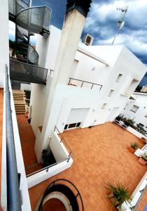 a large white building with a tile courtyard at Villa Solimar in L'Ampolla