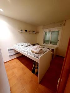 Cette petite chambre comprend un lit et une fenêtre. dans l'établissement Villa Solimar, à L'Ampolla