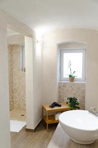 a bathroom with a large tub and a window at Modern Stone Apartment in the Heart of Bari in Bari