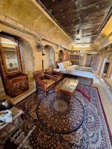 Desert Haveli Guest House في جيلسامر: غرفة القطار فيها سرير وسجادة