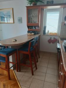 a kitchen with a wooden table and chairs at Promajna apartman in Promajna