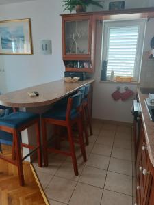 a kitchen with a wooden table and chairs at Promajna apartman in Promajna +3 photos