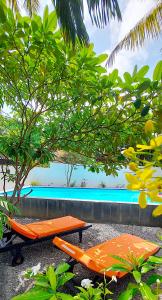 two orange lounge chairs next to a swimming pool at Calm Villa Wadduwa in Wadduwa
