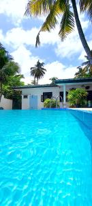 une grande piscine bleue en face d'une maison dans l'établissement Calm Villa Wadduwa, à Wadduwa