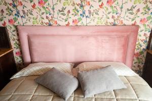 1 dormitorio con 1 cama rosa y 2 almohadas en CA’du LIN, en Cisterna dʼAsti