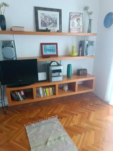 a living room with a tv and wooden shelves at Promajna apartman in Promajna