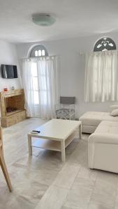 a living room with a couch and a coffee table at Amedi Villas Tinos in Pánormos