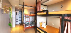 - une chambre avec 3 lits superposés dans une maison dans l'établissement Pukka Hostel • El Nido, à El Nido