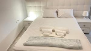 a large white bed with two towels on it at Amedi Villas Tinos in Pánormos