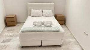 a large white bed with two pillows on it at Amedi Villas Tinos in Pánormos