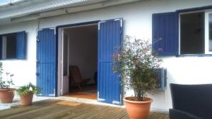 a house with blue doors and plants on a deck at La Minaude in Saint-Denis +2 photos