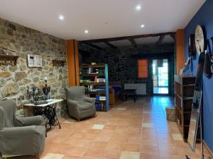 sala de estar con sillas y pared de piedra. en Agroturismo Gure Naia, en Carranza