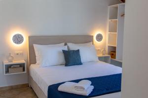 a bedroom with a white bed with two towels on it at Your Destination in Lixouri