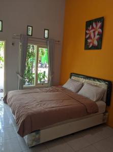 a bedroom with a large bed with a window at Clover Homestay in Probolinggo