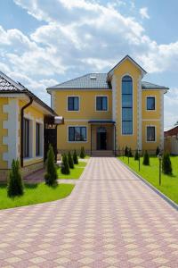 a large yellow house with a driveway at Hotel Sharm in Khimki