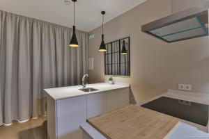 a kitchen with white cabinets and a sink and a window at Apartamentos Bela in Cangas de Morrazo +29 photos