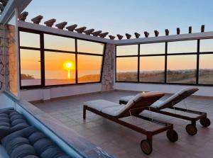 una sala de estar con vistas a la puesta de sol. en Casa das Rosas en Carvoeira