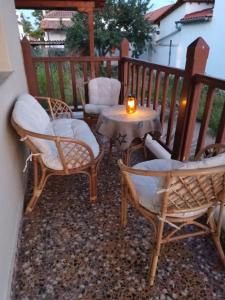 a patio with chairs and a table with a candle at Villa Despina in Nea Iraklia
