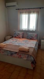 a bed in a room with a window and a bed sidx sidx sidx at Villa Despina in Nea Iraklia