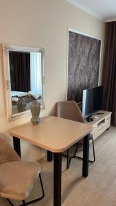 a living room with a table and a mirror at VALENCIA GARDENS ROYAL in Nesebar