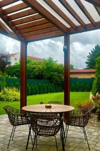 a patio with a table and chairs under a pergola at Central garden residence in Levice