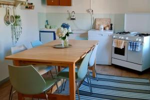 a kitchen with a wooden table with a vase of flowers on it at La casa di Elma in Brosso