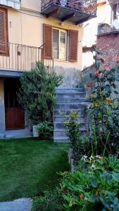 Brosso的住宿－La casa di Elma，房屋设有楼梯、阳台和庭院