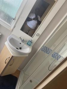 osoba robiąca zdjęcie umywalki w łazience w obiekcie Bird Lake Pastures 53 w mieście Northampton