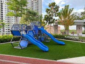 une aire de jeux avec un toboggan bleu dans un parc dans l'établissement Urban Suites Georgetown, Penang, à Jelutong