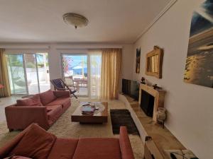 een woonkamer met een bank en een tv bij Sea Front Villa near Athens in Isthmia