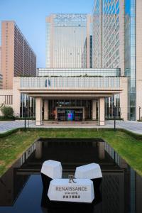 西安市にあるRenaissance Xi'an Hotelの白い椅子が2脚前にある建物