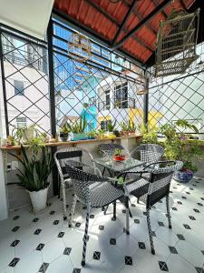 a patio with a table and chairs and plants at Vika Homestay in Ho Chi Minh City
