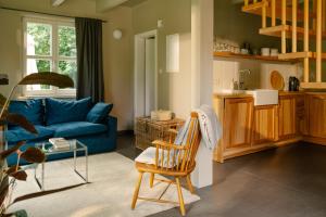 a living room with a blue couch and a chair at Michelberger Farm in Vetschau +18 photos