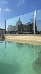una gran piscina de agua frente a un edificio en Catedral Suites Jerez en Jerez de la Frontera