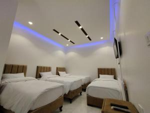 Habitación con 4 camas con luz azul en Mussa Spring Hotel, en Wadi Musa