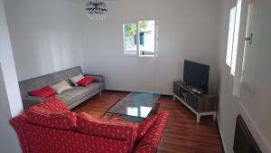 a living room with a couch and a tv at La Minaude in Saint-Denis