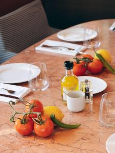 a table with tomatoes and a bottle of oil and glasses at Hôtel & Spa Belle Plage in Cannes