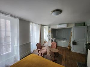 Cette chambre comprend un lit, des chaises et une baignoire. dans l'établissement LE ZOLA, à Bourges