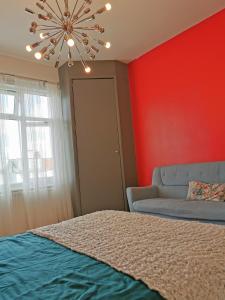 a bedroom with a bed and a couch and a chandelier at Large Double Room with Private Toilet and Shower in Southend-on-Sea