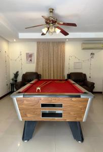 a pool table in a living room with a ceiling fan at Blooming Hill Boutique Suites in Pattaya South