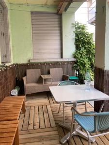 un patio con una mesa blanca y sillas en un porche en CHACHACHA appartement de charme calme balcon en Mulhouse