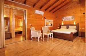 a bedroom with a bed and two chairs in a room at מצוקי גורן in Goren