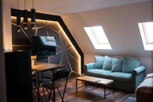 a living room with a blue couch and a table at The Home Sweet Home Studio Apartment in Gheorgheni