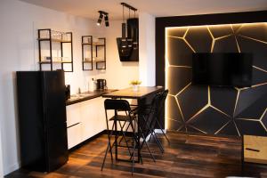 uma cozinha com uma mesa com cadeiras e uma televisão em The Home Sweet Home Studio Apartment em Gheorgheni