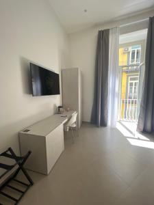 a white room with a desk and a window at Dimora Chiaia 209 in Naples