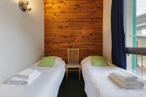 two beds in a room with a wooden wall at Chamonix Sud - Balme 302 - Happy Rentals in Chamonix-Mont-Blanc