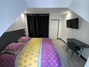 ein kleines Schlafzimmer mit einem Bett und einem Schreibtisch in der Unterkunft Residence Gaby & Tom 4 Étoiles in Contrexéville