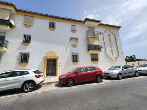 3 voitures garées devant un bâtiment dans l'établissement Apt Buenavista en Torremolinos increíbles vistas hacia Málaga 5min del centro y de la playa, à Torremolinos