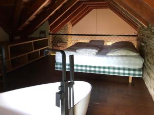 Schlafzimmer mit einem Bett und einer Badewanne in der Unterkunft Záhradný domček in Levoča