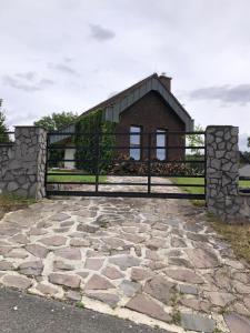 a house with a gate and a stone driveway at Záhradný domček in Levoča